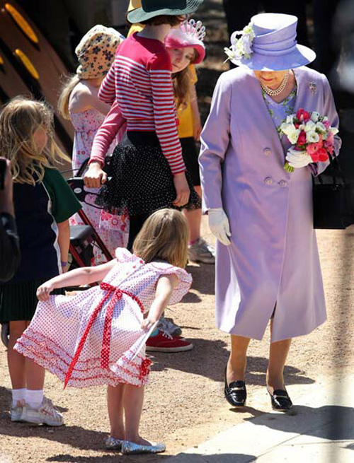 A young girl doing a curtsy for queen Elizabeth II