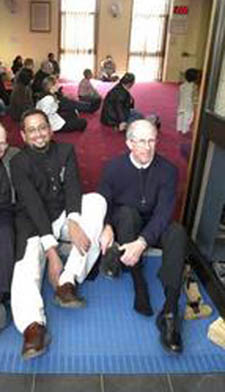 A priest removes his shoes before entering mosque