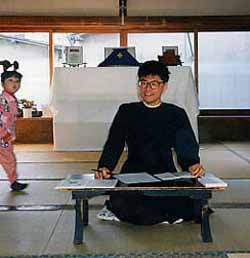 A japanese Catholic priest sitting Buddhist style