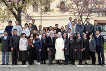 People in religious and civilian garb posing in front of a building for pastoral formation